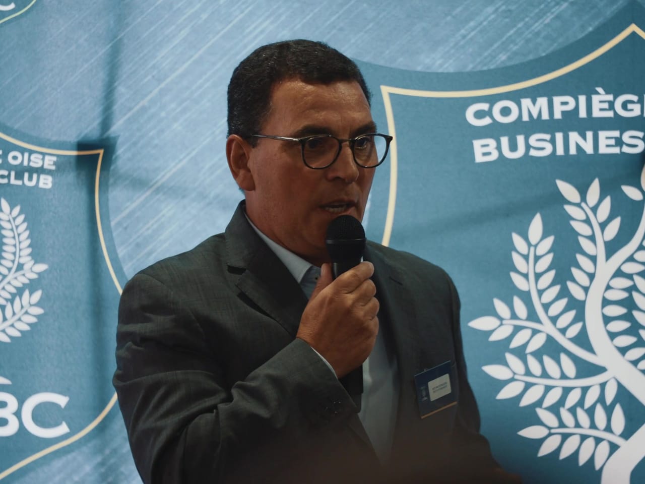 Prise de parole au micro devant le logo du Compiègne Oise Business Club