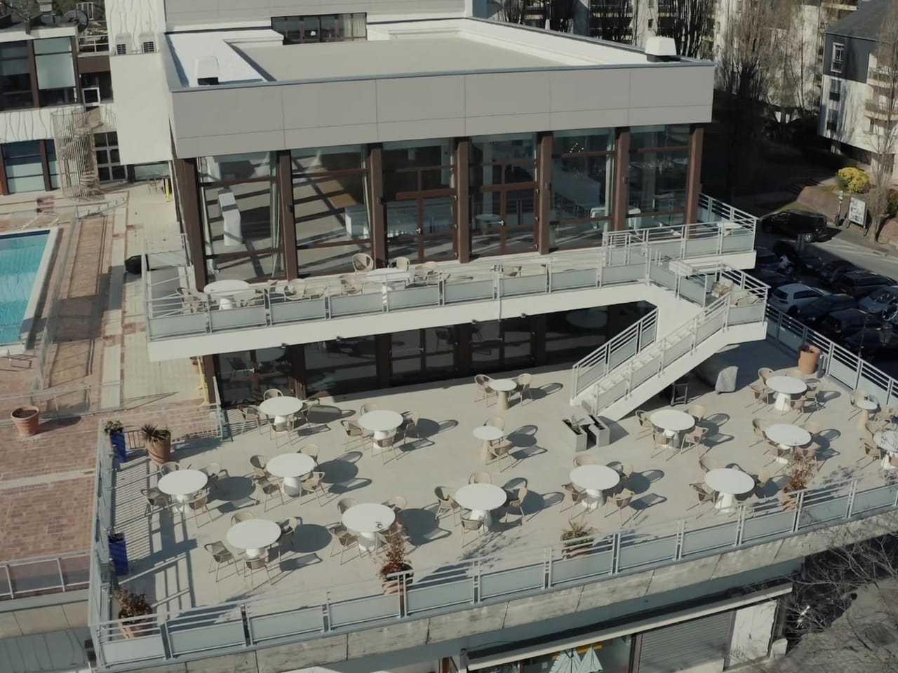 Terrasse et restaurant d'un hôtel au bord de l'eau, vus par drone