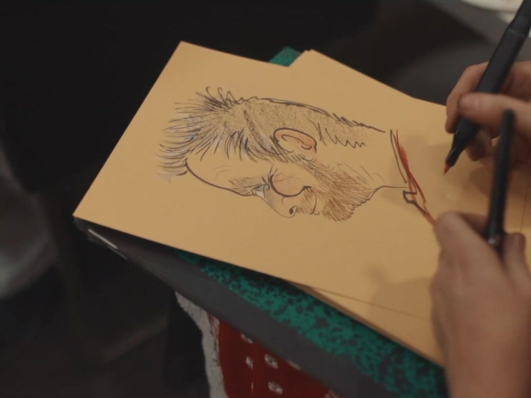 Caricaturiste dessinant un salarié pendant la fête de Noël de l'entreprise