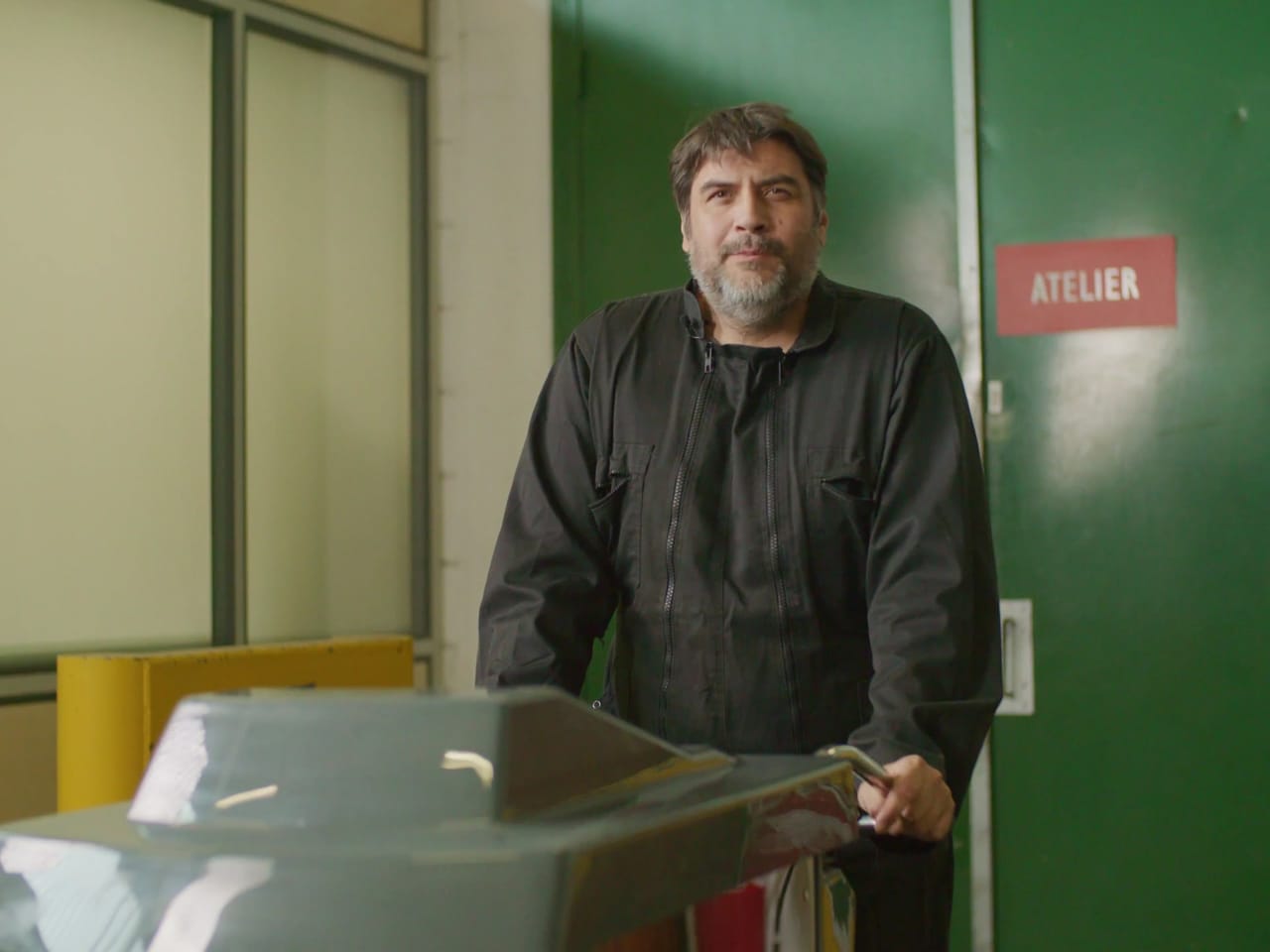 Technicien filmé devant la porte de son atelier pour un film d'entreprise
