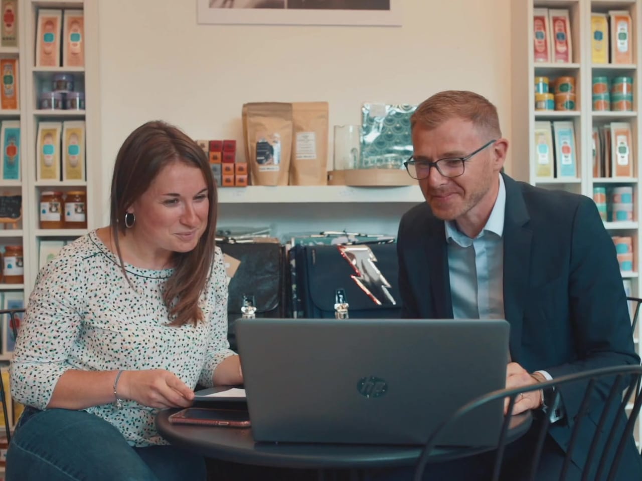 L'expert-comptable chez une cliente commerçante, devant un ordinateur