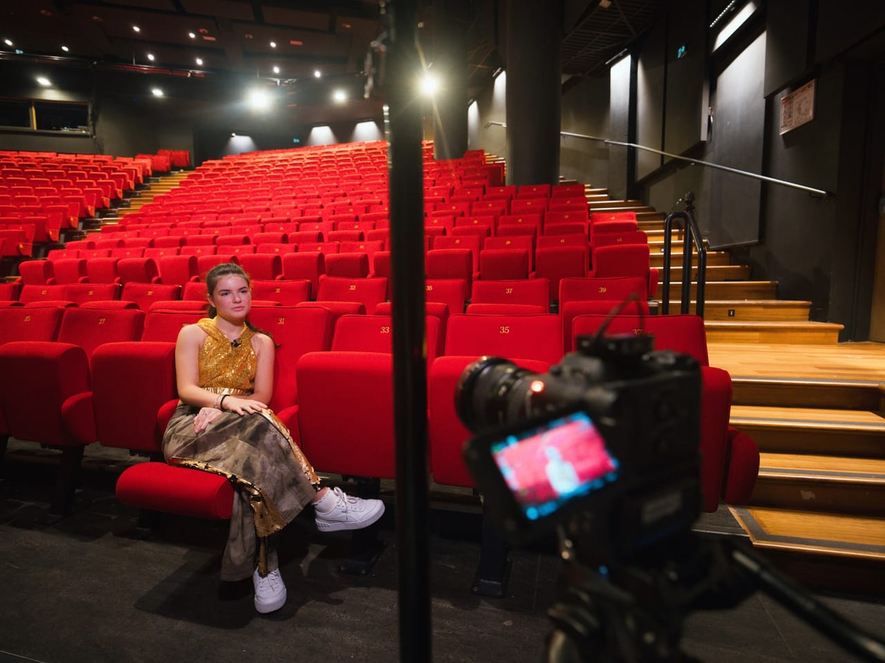 Interview filmée dans une salle de spectacle, caméra au premier plan